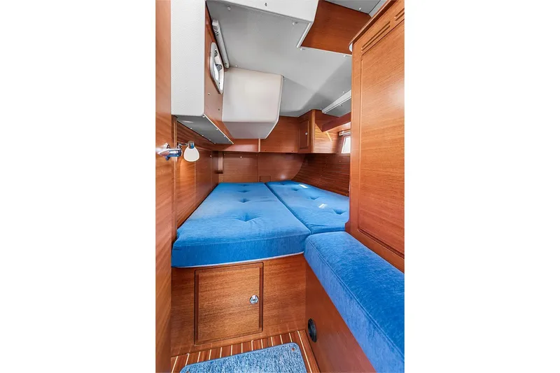  Yacht Photos Pics Interior of 2022 Hallberg-Rassy 400 yacht with blue cushions and wooden finish.