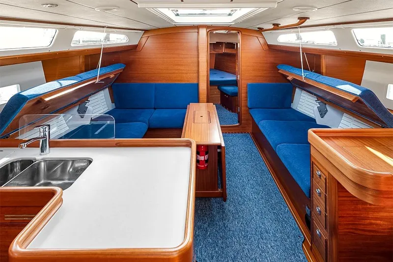  Yacht Photos Pics Interior of 2022 Hallberg-Rassy 400 yacht with blue seating and wooden finishes.