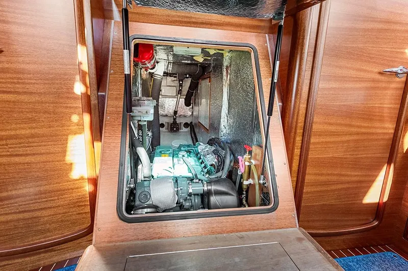  Yacht Photos Pics Engine compartment of 2022 Hallberg-Rassy 400 yacht, showcasing mechanical components and wooden interior.