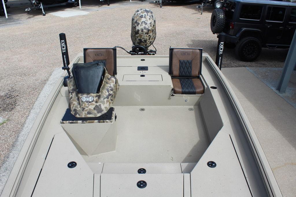 2026 Excel Bolt 183 boat interior with camo and leather seats, parked outdoors.