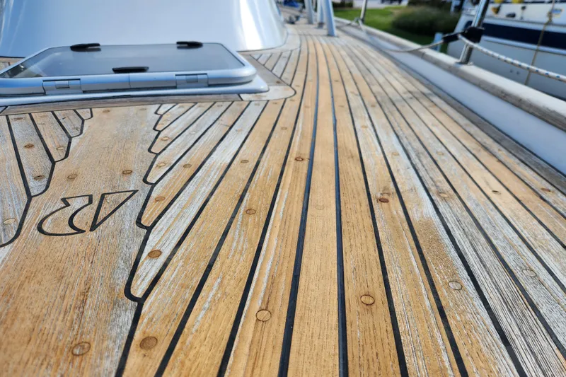 Glendora Yacht Photos Pics Teak deck of 2007 Hallberg-Rassy 37 sailboat, featuring intricate wood patterns and hatch.