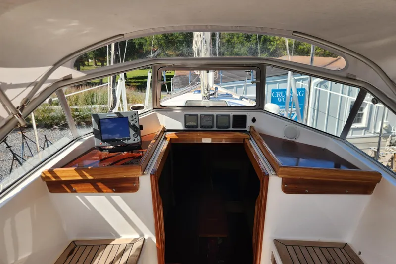 Glendora Yacht Photos Pics Cockpit of 2007 Hallberg-Rassy 37 sailboat with navigation equipment and wooden trim.