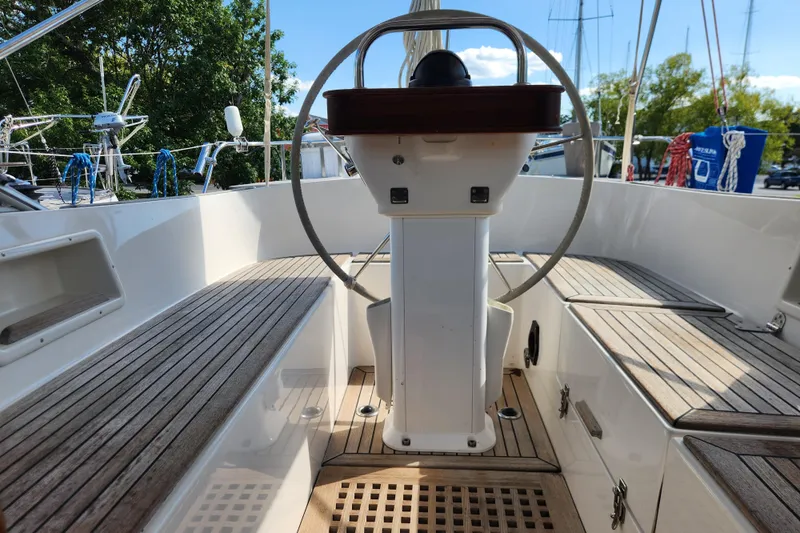 Glendora Yacht Photos Pics Cockpit of 2007 Hallberg-Rassy 37 sailboat with wooden seating and steering wheel.
