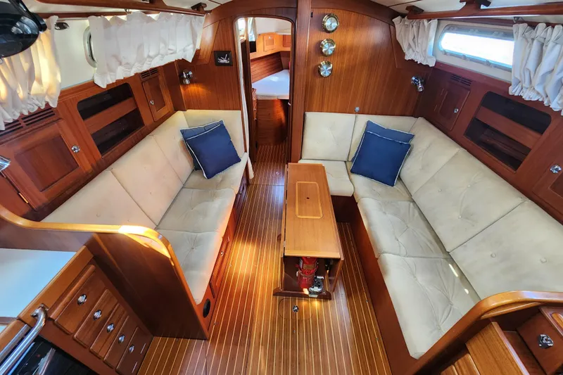Glendora Yacht Photos Pics Interior of 2007 Hallberg-Rassy 37 yacht with wooden finish and beige seating.