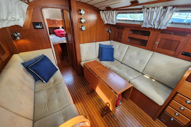 Glendora Yacht Photos Pics Interior of 2007 Hallberg-Rassy 37 yacht with cozy seating and wooden finishes.