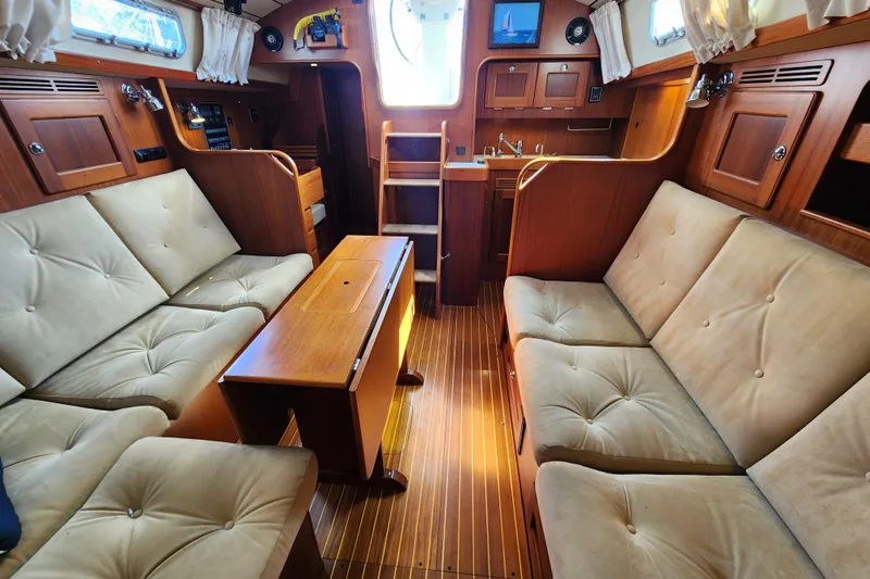 Glendora Yacht Photos Pics Luxurious interior of 2007 Hallberg-Rassy 37 yacht with plush seating and wooden finishes.