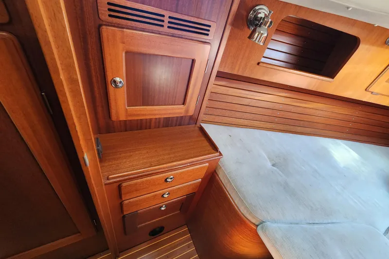 Glendora Yacht Photos Pics Interior of 2007 Hallberg-Rassy 37 yacht with wooden cabinetry and cushioned seating.