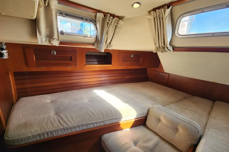 Glendora Yacht Photos Pics Cozy cabin interior of 2007 Hallberg-Rassy 37 sailboat with wooden accents and cushioned seating.