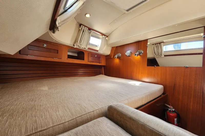 Glendora Yacht Photos Pics Interior of 2007 Hallberg-Rassy 37 yacht cabin with wooden finish and cozy bed.