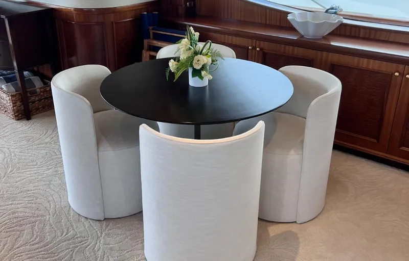 Miss Stephanie Yacht Photos Pics Luxurious yacht interior with round table, white chairs, and floral centerpiece, Richmond Yachts 2004.