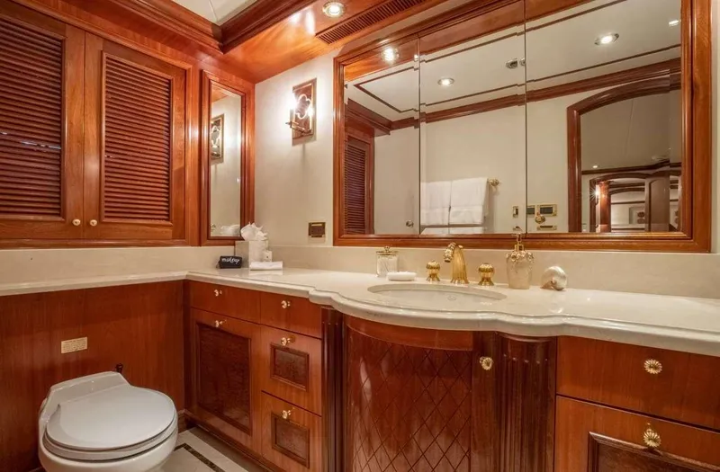 Miss Stephanie Yacht Photos Pics Luxurious yacht bathroom with wooden cabinetry, gold fixtures, and large mirror, Richmond Yachts 2004.