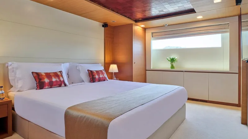 Kintaro Yacht Photos Pics Luxurious bedroom interior on 2005 Cantieri di Pisa Akhir 38 yacht, featuring elegant decor and natural light.