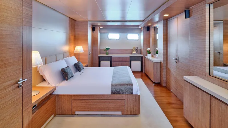 Kintaro Yacht Photos Pics Luxurious bedroom interior on 2005 Cantieri di Pisa Akhir 38 yacht, featuring elegant wood finishes.