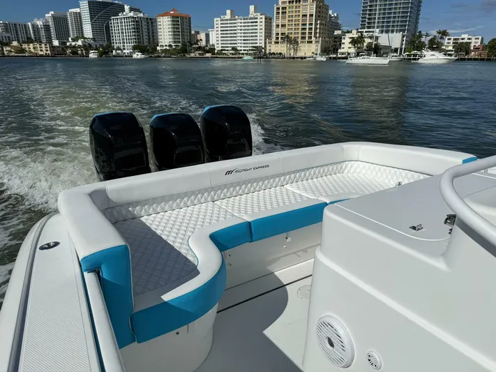  Yacht Photos Pics 2012 Midnight Express 37 Open boat with triple engines, cruising near city skyline.