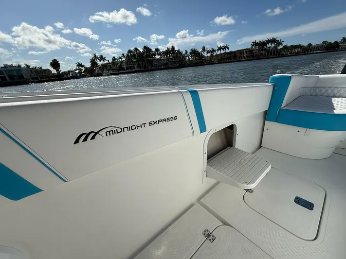  Yacht Photos Pics 2012 Midnight Express 37 Open boat interior with seating, docked by a scenic waterfront.