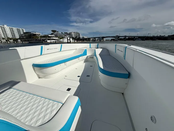  Yacht Photos Pics 2012 Midnight Express 37 Open boat with white and blue seating, docked near waterfront buildings.