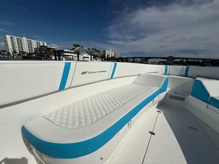  Yacht Photos Pics 2012 Midnight Express 37 Open boat with blue and white seating, docked near buildings and a bridge.