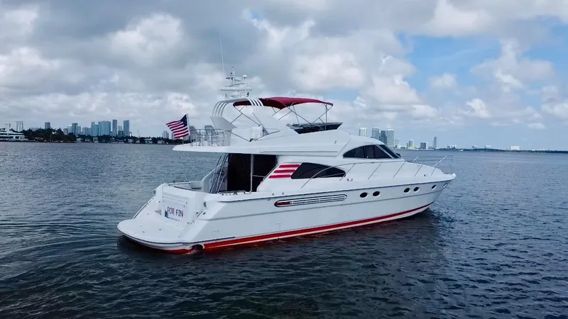 Por Fin Yacht Photos Pics 1999 Fairline Squadron 65 yacht on calm waters with city skyline in background.