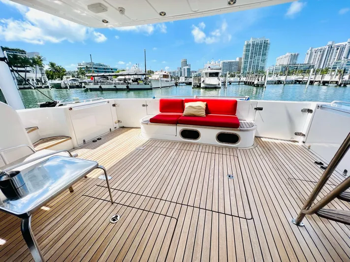 Por Fin Yacht Photos Pics 1999 Fairline Squadron 65 yacht deck with red seating, marina view.