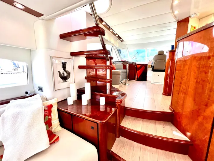 Por Fin Yacht Photos Pics Luxurious interior of a 1999 Fairline Squadron 65 yacht with wooden stairs and modern decor.