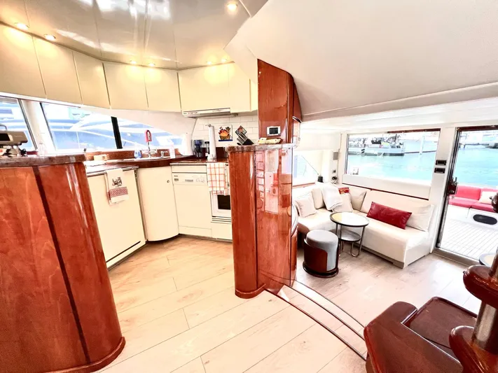 Por Fin Yacht Photos Pics Luxurious interior of 1999 Fairline Squadron 65 yacht with modern kitchen and cozy seating area.