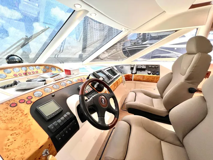 Por Fin Yacht Photos Pics Luxurious helm of a 1999 Fairline Squadron 65 yacht with modern controls and plush seating.