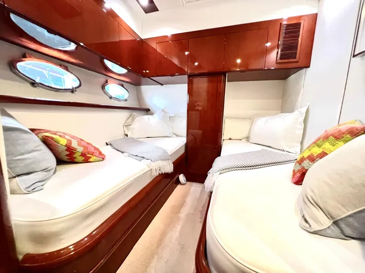 Por Fin Yacht Photos Pics Luxurious cabin interior of 1999 Fairline Squadron 65 yacht with twin beds and portholes.