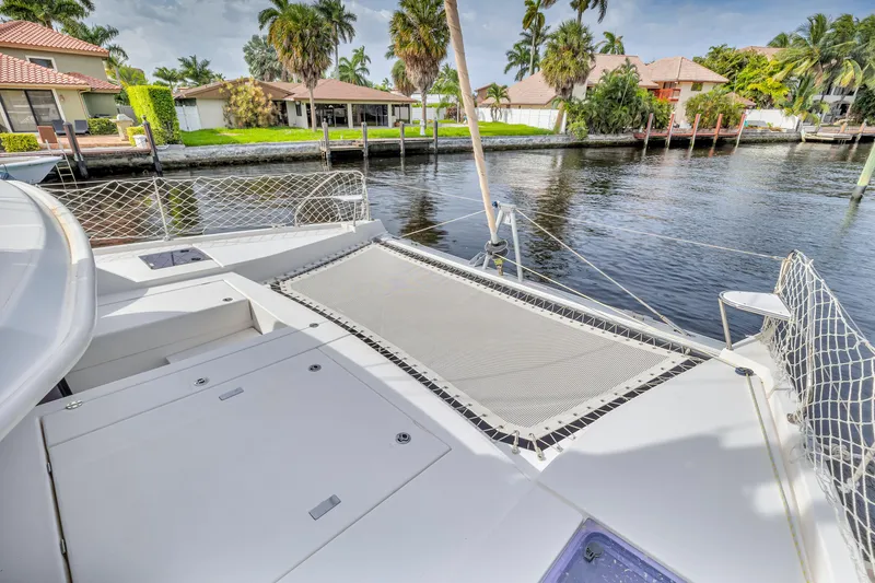  Yacht Photos Pics Catamaran deck with netting, Leopard 40, 2017, docked near waterfront homes and palm trees.