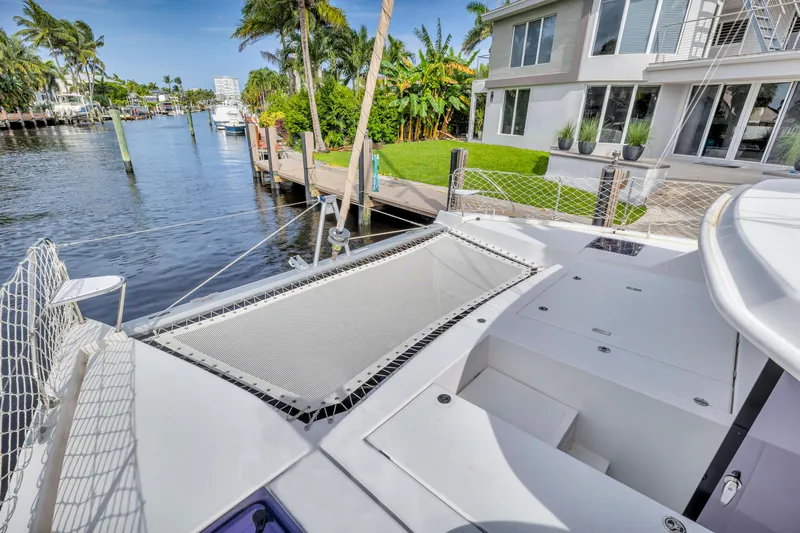  Yacht Photos Pics 2017 Leopard 40 catamaran docked by waterfront home, featuring spacious deck and netting.