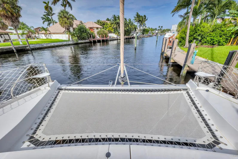 Yacht Photos Pics Catamaran deck view on a 2017 Leopard 40, overlooking a serene canal with lush greenery.