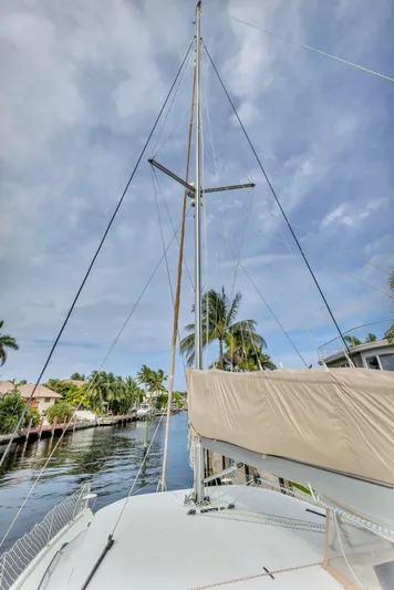  Yacht Photos Pics Sailing yacht Leopard 40, 2017 model, docked by palm-lined canal under cloudy sky.