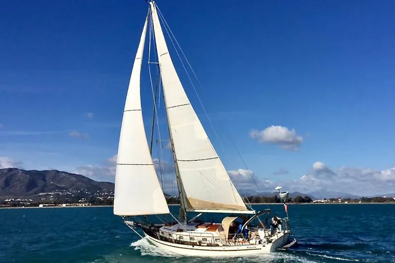 Begonia Yacht Photos Pics Sailing yacht "Atkin & Lange Cutter" 1988 on open sea with mountains in background.