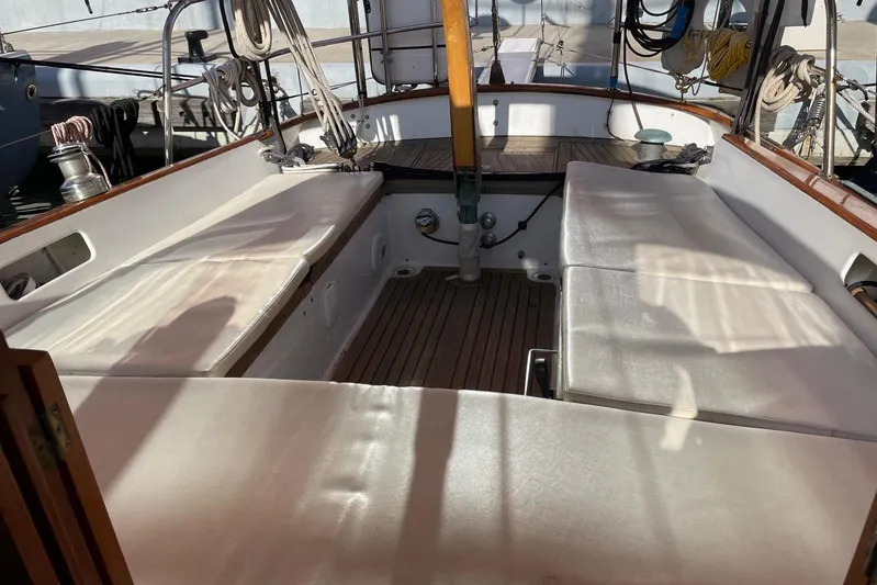 Begonia Yacht Photos Pics Interior view of 1988 Custom Atkin & Lange Cutter sailboat with white seating and wooden accents.