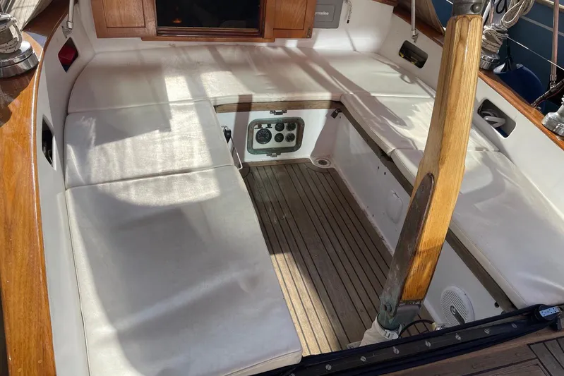 Begonia Yacht Photos Pics 1988 Custom Atkin & Lange Cutter sailboat cockpit with wooden tiller and cushioned seating.