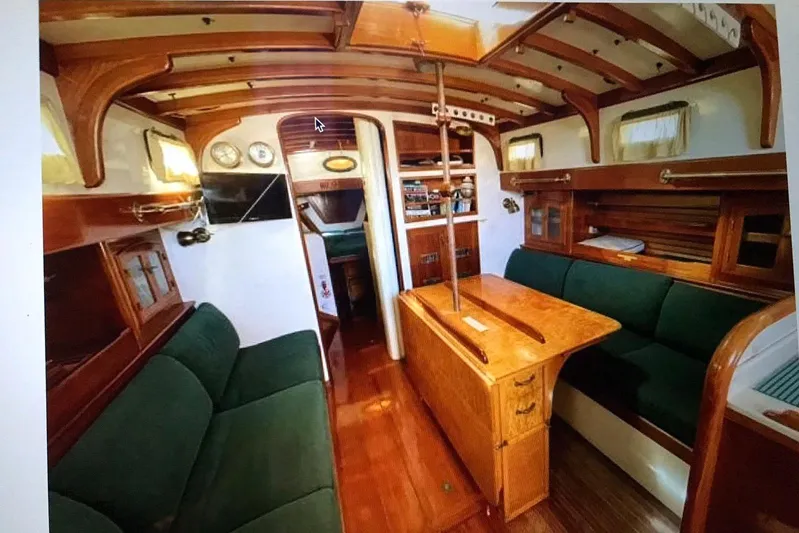 Begonia Yacht Photos Pics Interior of 1988 Custom Atkin & Lange Cutter with wooden furnishings and green seating.