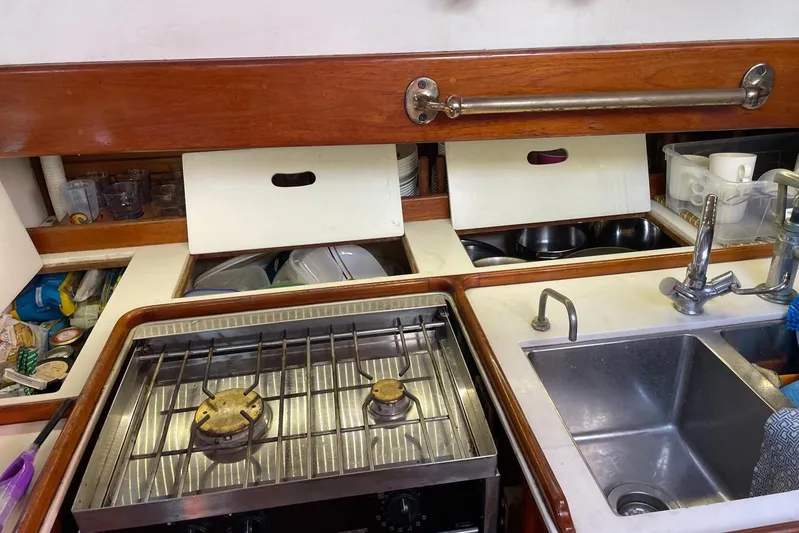 Begonia Yacht Photos Pics Compact kitchen area on a 1988 Custom Atkin & Lange Cutter sailboat, featuring stove and sink.