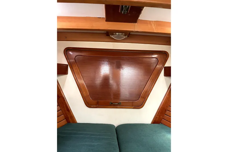Begonia Yacht Photos Pics Interior of 1988 Custom Atkin & Lange Cutter with wooden paneling and green cushions.