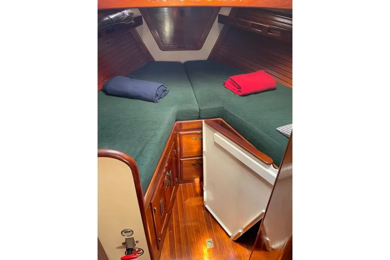 Begonia Yacht Photos Pics Cozy cabin interior of 1988 Custom Atkin & Lange Cutter with green bedding and wooden finish.