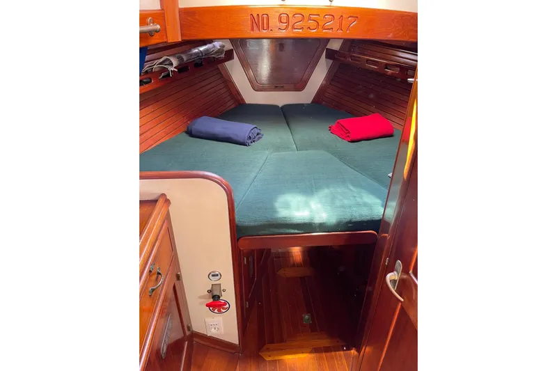 Begonia Yacht Photos Pics Cozy cabin interior of 1988 Custom Atkin & Lange Cutter with green bedding and wooden finish.