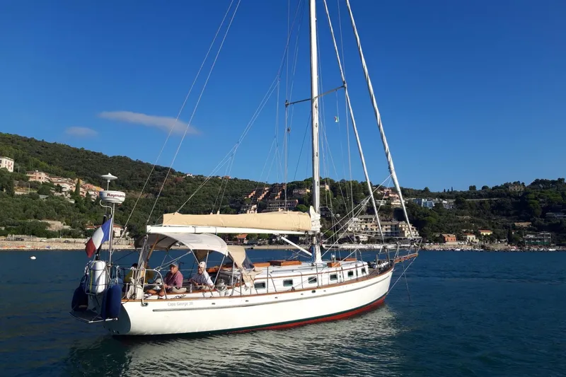 Begonia Yacht Photos Pics Sailing yacht "Atkin & Lange Cutter" 1988 on calm waters near a coastal town.