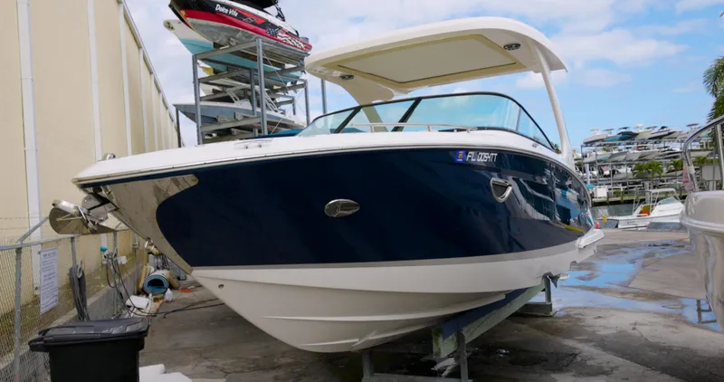  Yacht Photos Pics 2022 Regal 29 OBX boat in marina, blue hull, white deck, stored on lift.
