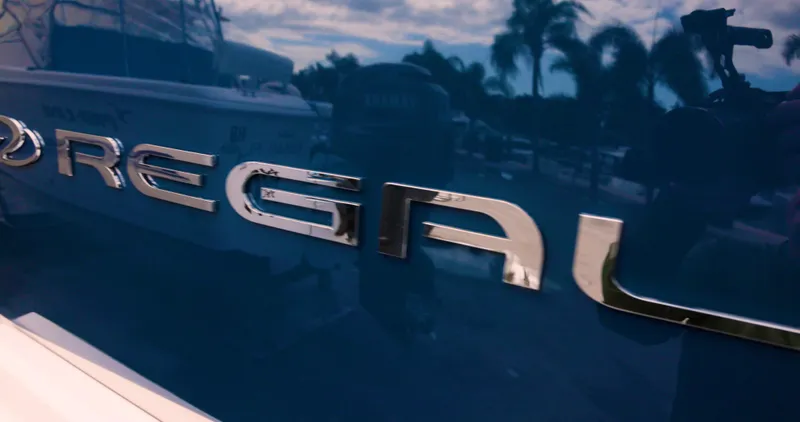  Yacht Photos Pics 2022 Regal 29 OBX boat logo with palm trees reflecting on glossy surface.