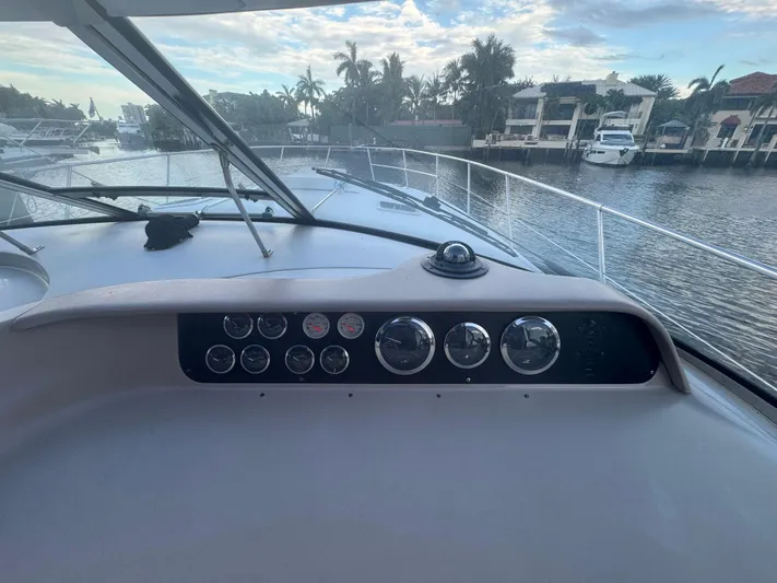 Los Sue&Ntilde;os Yacht Photos Pics 1999 Sea Ray 400 Sundancer dashboard with gauges, overlooking a serene waterfront view.