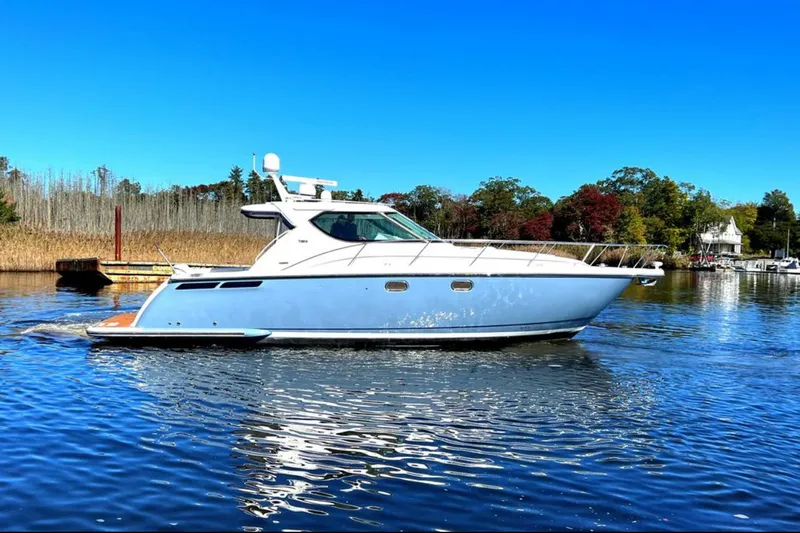 Relentless Yacht Photos Pics 2006 Tiara Yachts 4300 Sovran cruising on a serene lake under a clear blue sky.