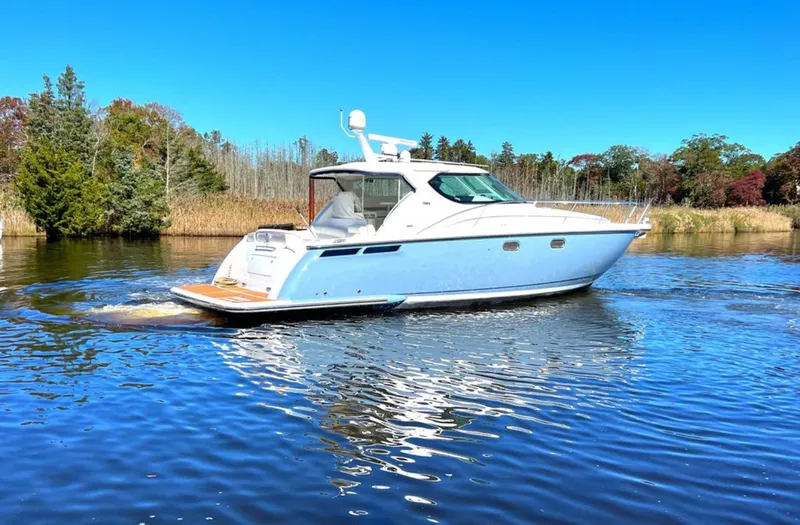 Relentless Yacht Photos Pics 2006 Tiara Yachts 4300 Sovran cruising on a serene lake under a clear blue sky.