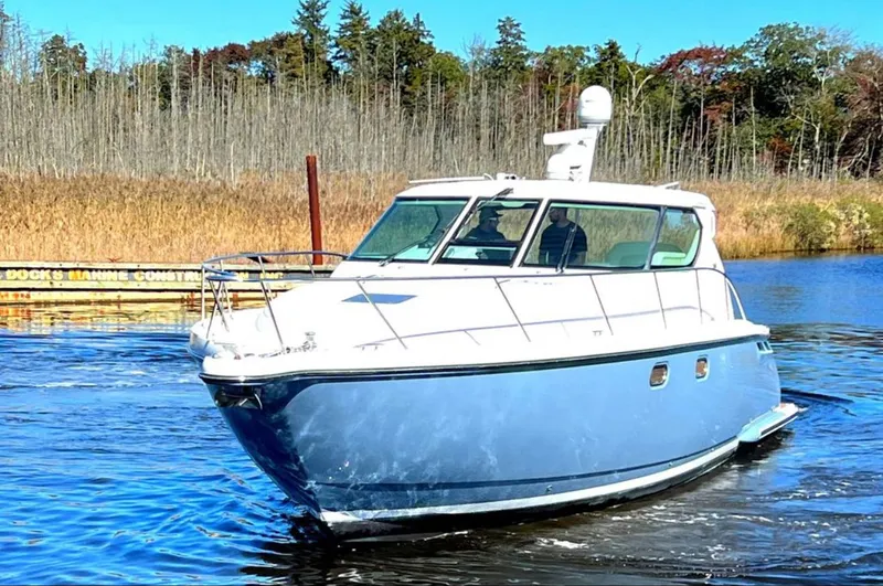 Relentless Yacht Photos Pics 2006 Tiara Yachts 4300 Sovran cruising on a calm river with forested background.