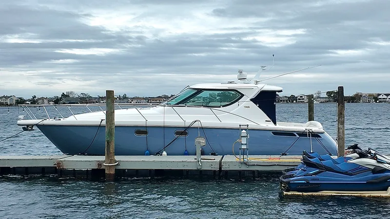 Relentless Yacht Photos Pics 2006 Tiara Yachts 4300 Sovran docked beside jet skis on a cloudy day.