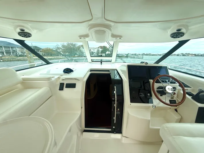 Relentless Yacht Photos Pics 2006 Tiara Yachts 4300 Sovran helm with steering wheel, navigation screens, and waterfront view.