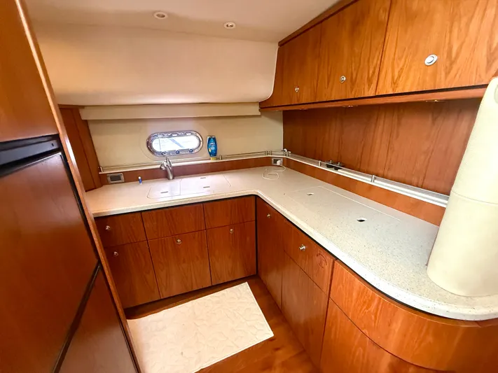Relentless Yacht Photos Pics 2006 Tiara Yachts 4300 Sovran kitchen with wood cabinets and sleek countertops.