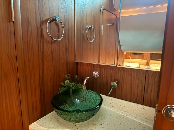 Relentless Yacht Photos Pics Luxurious bathroom in 2006 Tiara Yachts 4300 Sovran with glass sink and wood paneling.